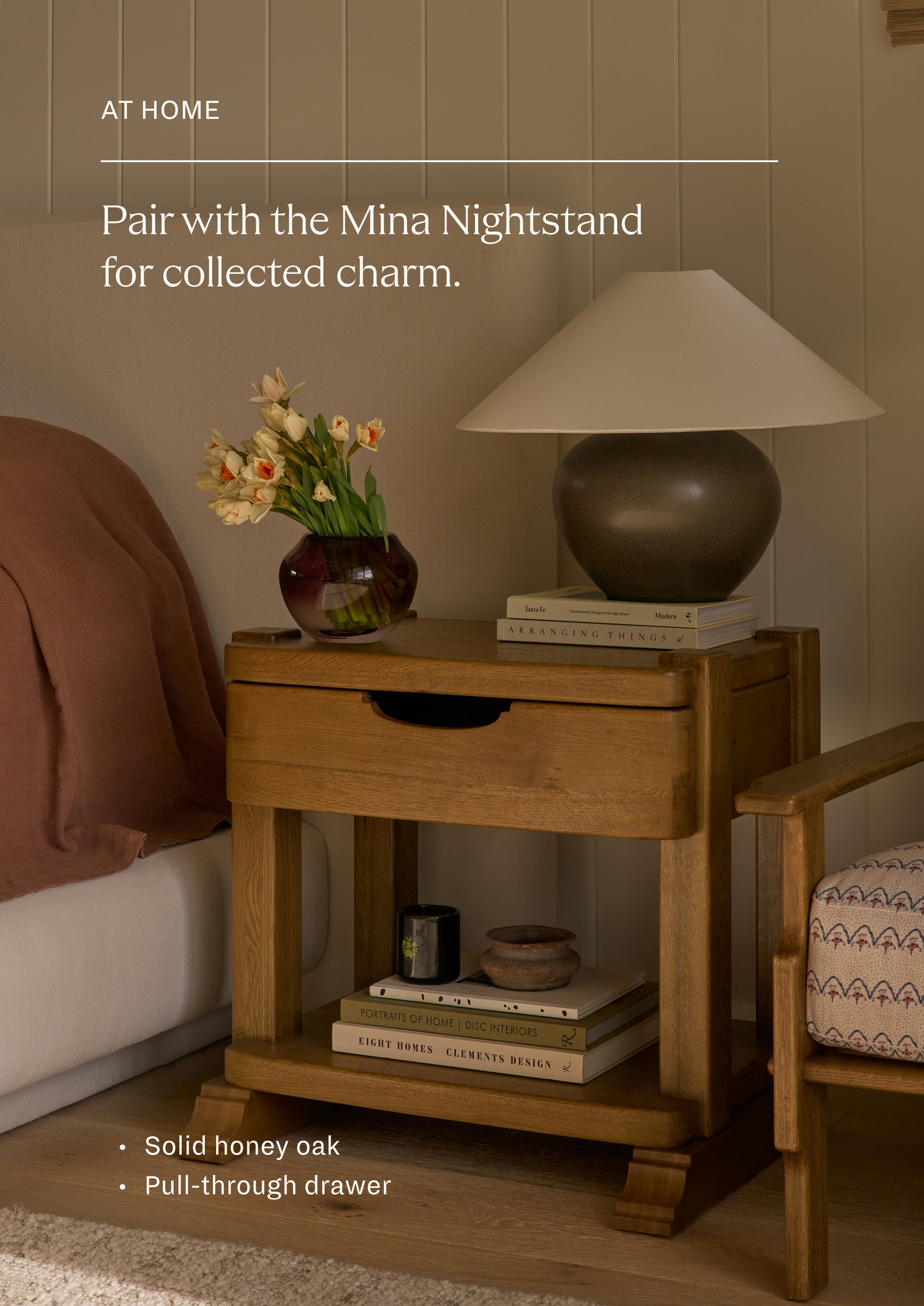 Pair with the Mina Nightstand for collected charm. Bedroom featuring a honey oak nightstand styled beside an upholstered bed. The image highlights the coordinated materials and warm, collected aesthetic shared across the Mina collection.