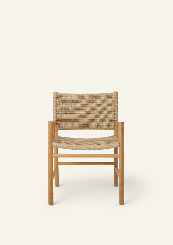 Front view of the dining armchair featuring a handwoven synthetic paper cord seat and backrest framed by solid teak. The balanced proportions and supportive armrests bring comfort and timeless style to any dining setting.