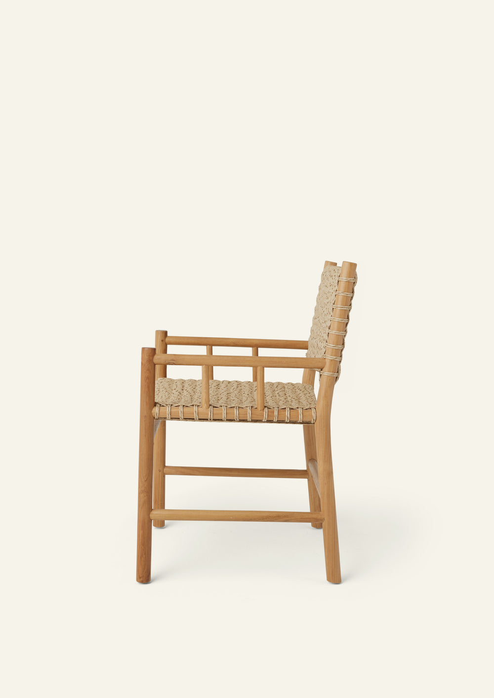 Side profile of an outdoor dining armchair crafted from solid high-grade teak and woven synthetic paper cord. Integrated armrests and a gently reclined back create a comfortable silhouette suited for indoor and outdoor living.