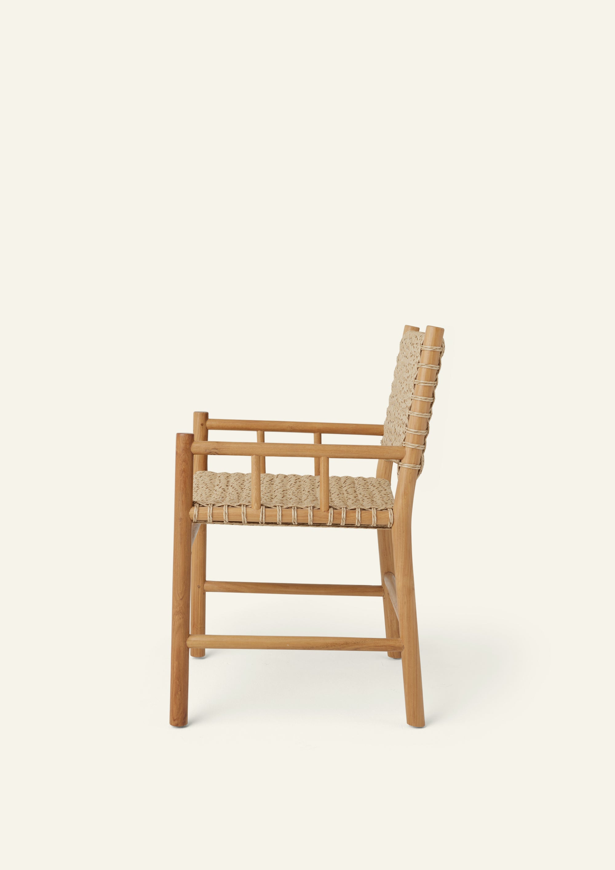 Side profile of an outdoor dining armchair crafted from solid high-grade teak and woven synthetic paper cord. Integrated armrests and a gently reclined back create a comfortable silhouette suited for indoor and outdoor living.