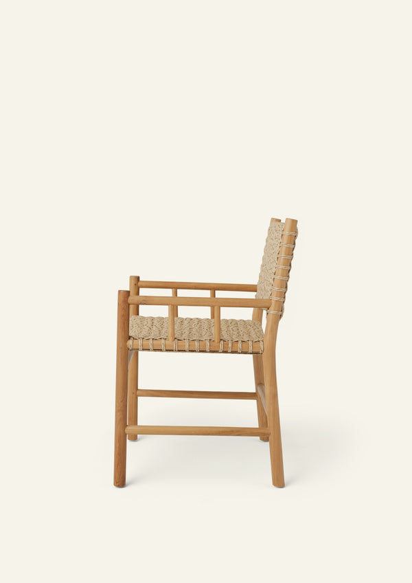 Side profile of an outdoor dining armchair crafted from solid high-grade teak and woven synthetic paper cord. Integrated armrests and a gently reclined back create a comfortable silhouette suited for indoor and outdoor living.