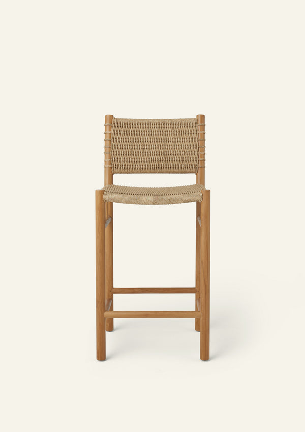 Front view of the woven counter stool showcasing its clean-lined teak frame, supportive woven backrest, and handwoven seat. Natural textures and simple proportions create a relaxed, timeless look.