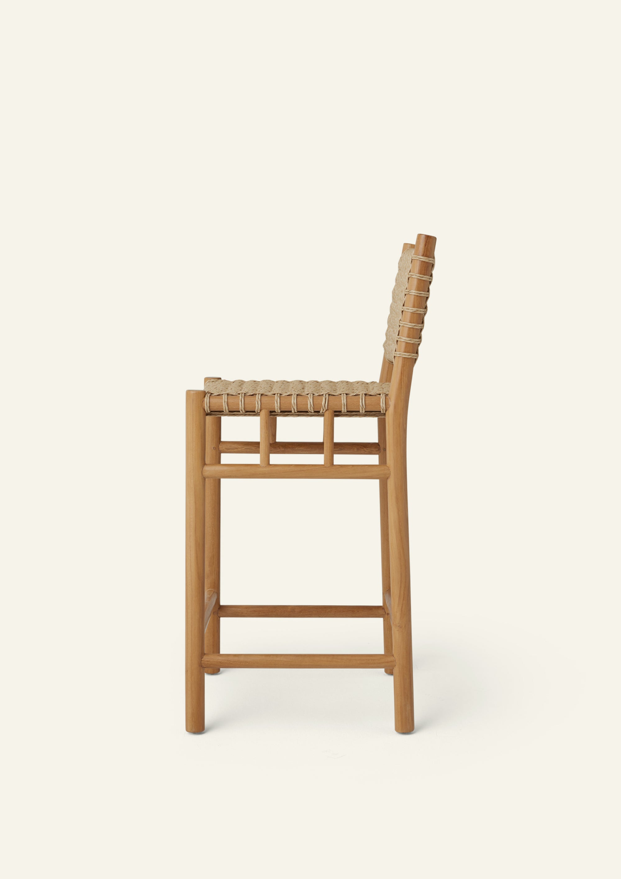 Side profile of the counter stool highlighting its gently reclined backrest, woven synthetic paper cord seat, and solid teak frame. The elevated proportions provide comfortable seating at kitchen islands and outdoor counters.
