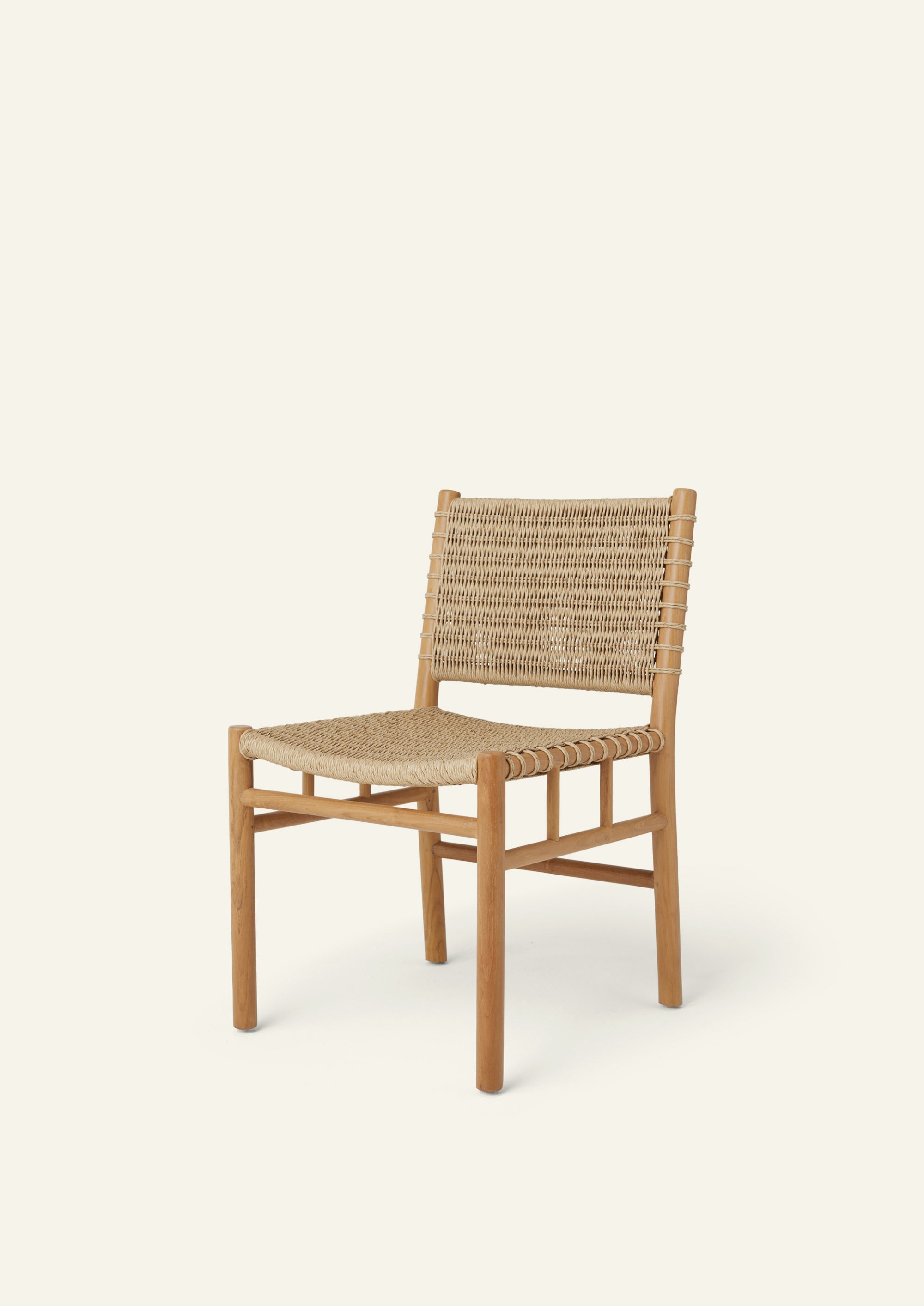 Three-quarter view of the woven dining chair featuring a solid teak frame and handwoven synthetic paper cord seat and backrest. The lightweight silhouette balances casual comfort with refined craftsmanship.