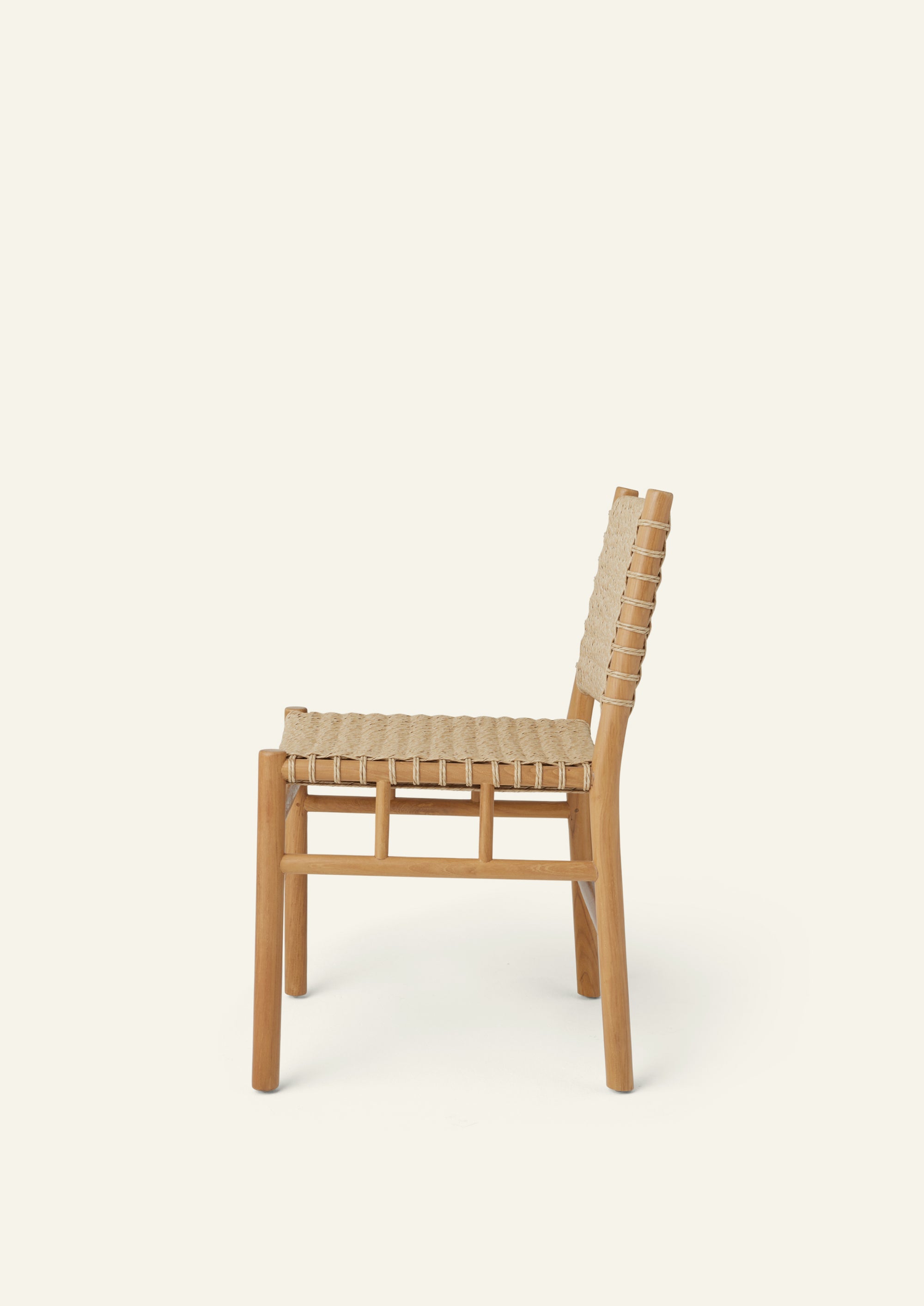 Side profile of a woven dining chair crafted from solid high-grade teak and outdoor synthetic paper cord. The gently reclined backrest and handwoven seat create a comfortable silhouette designed for indoor and outdoor dining.
