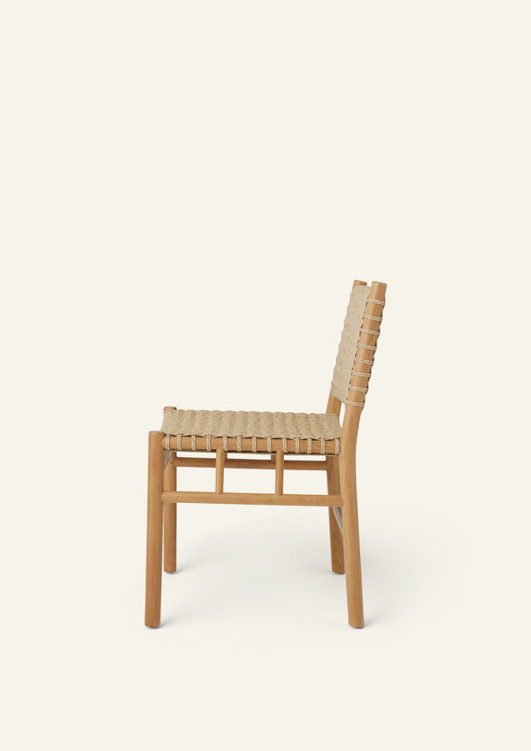 Side profile of a woven dining chair crafted from solid high-grade teak and outdoor synthetic paper cord. The gently reclined backrest and handwoven seat create a comfortable silhouette designed for indoor and outdoor dining.