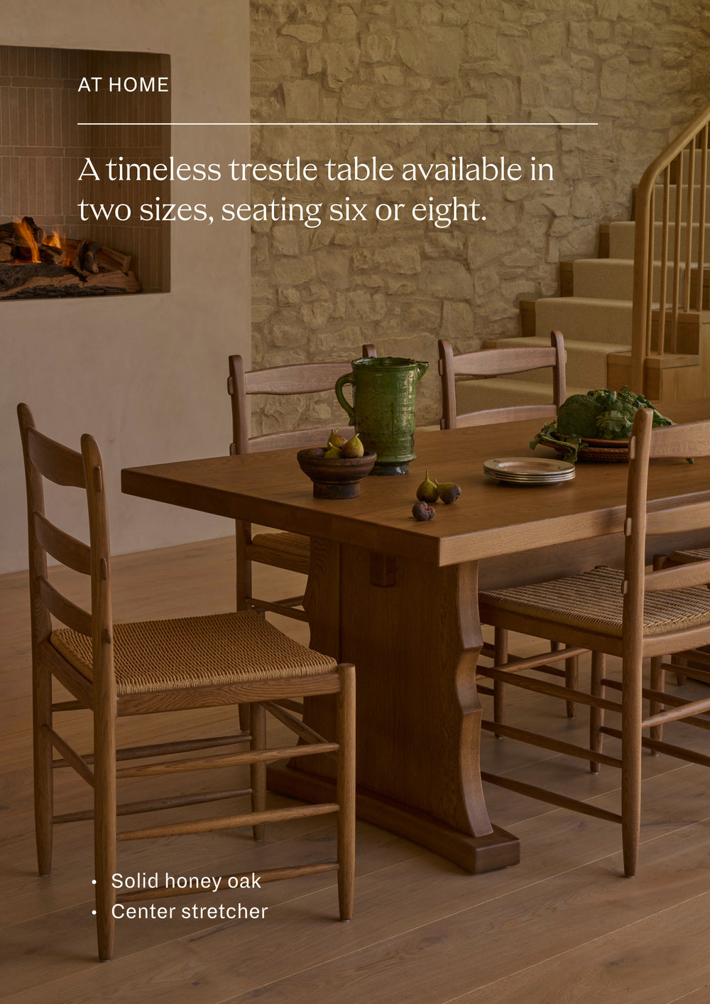 Available in two sizes, seating six or eight. The trestle dining table styled with coordinating woven-seat dining chairs in a warm, inviting dining room. Set beneath a stone fireplace, the table creates an elegant gathering place designed for everyday meals and larger celebrations alike.