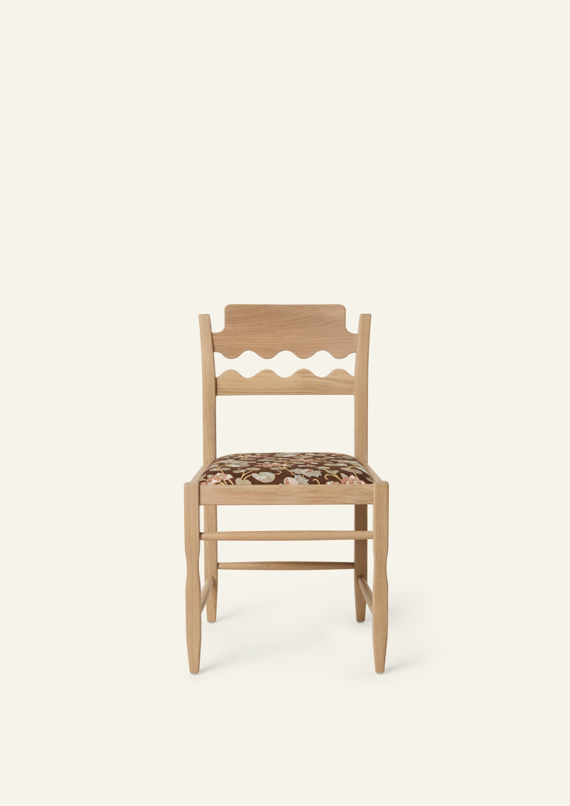 Front view of the Freda Razor Dining Chair in natural oak with an custom fabric seat. The hand-carved scalloped backrest adds a playful yet timeless detail.