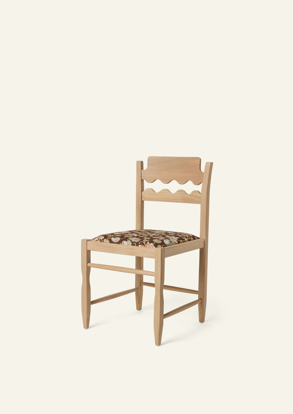Freda Razor Dining Chair in natural oak with an custom fabric seat, shown from an angled front view on a neutral background. The hand-carved scalloped backrest adds a playful yet timeless detail.