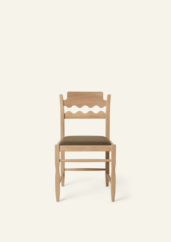 Front view of the Freda Razor Dining Chair in natural oak with an upholstered performance olive linen seat. The hand-carved scalloped backrest adds a playful yet timeless detail.
