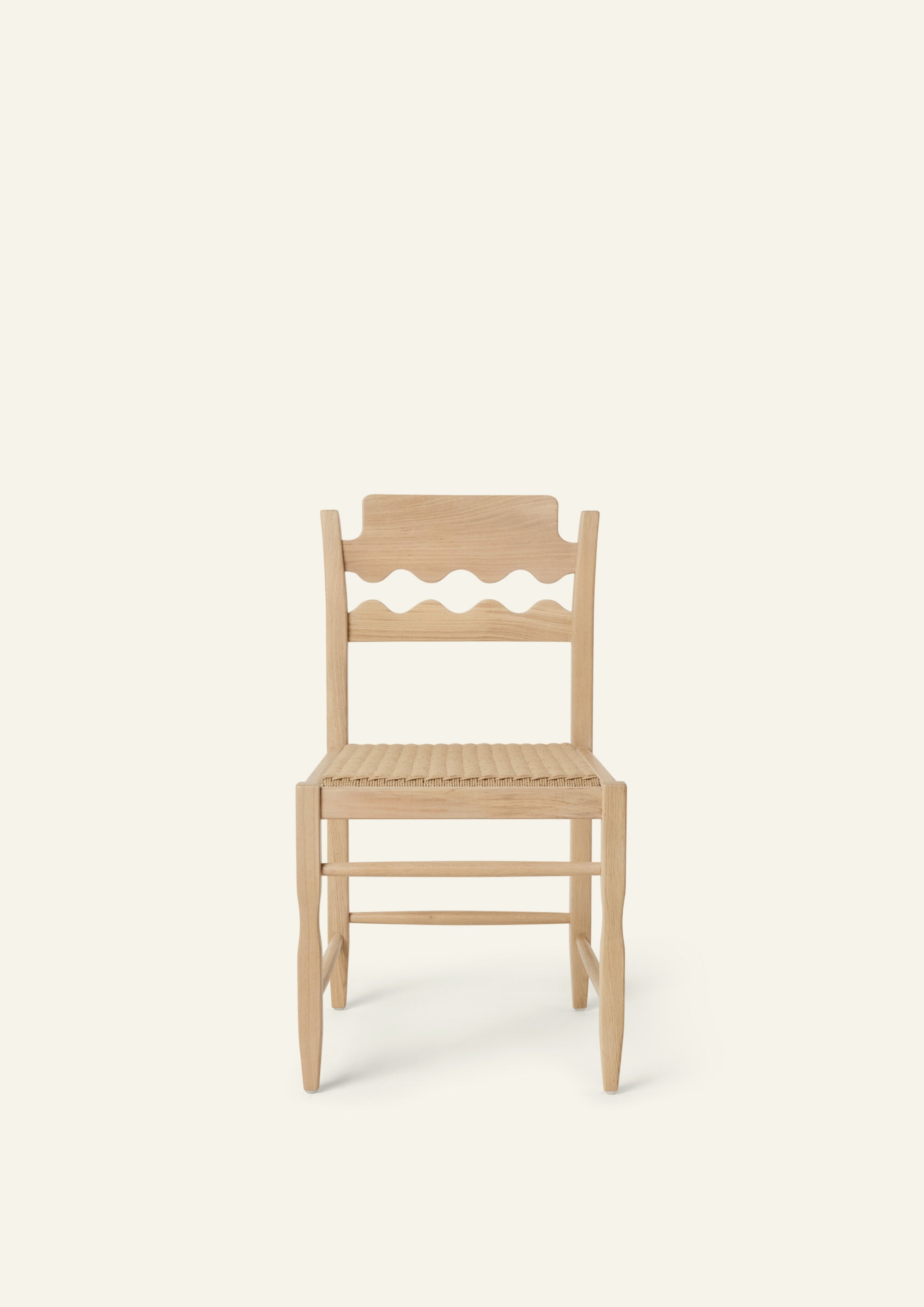Front view of the Freda Razor Dining Chair in natural oak with a woven paper cord seat. The hand-carved scalloped backrest adds a playful yet timeless detail.