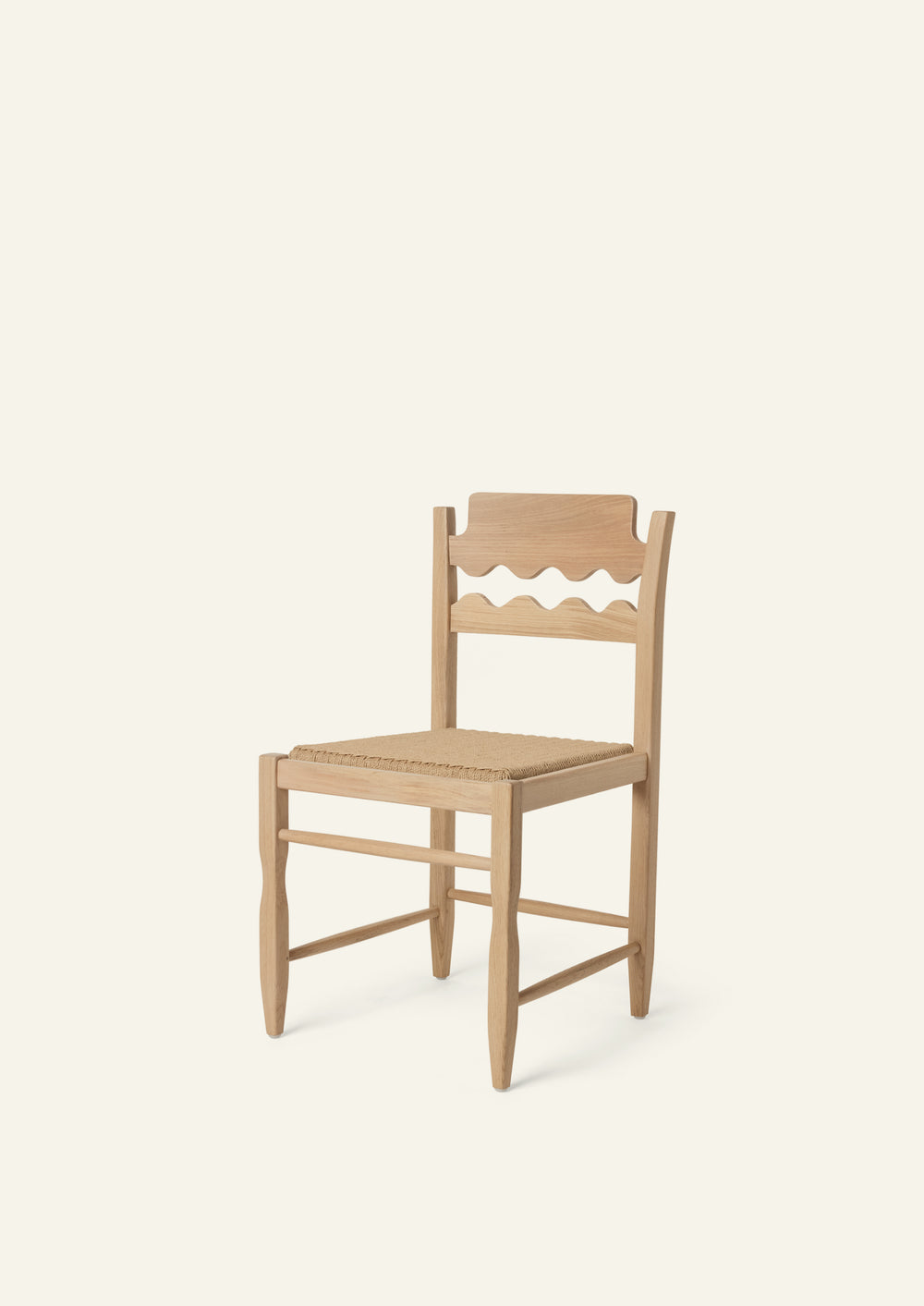 Freda Razor Dining Chair in natural oak with a woven paper cord seat, shown from an angled front view on a neutral background. The hand-carved scalloped backrest adds a playful yet timeless detail.