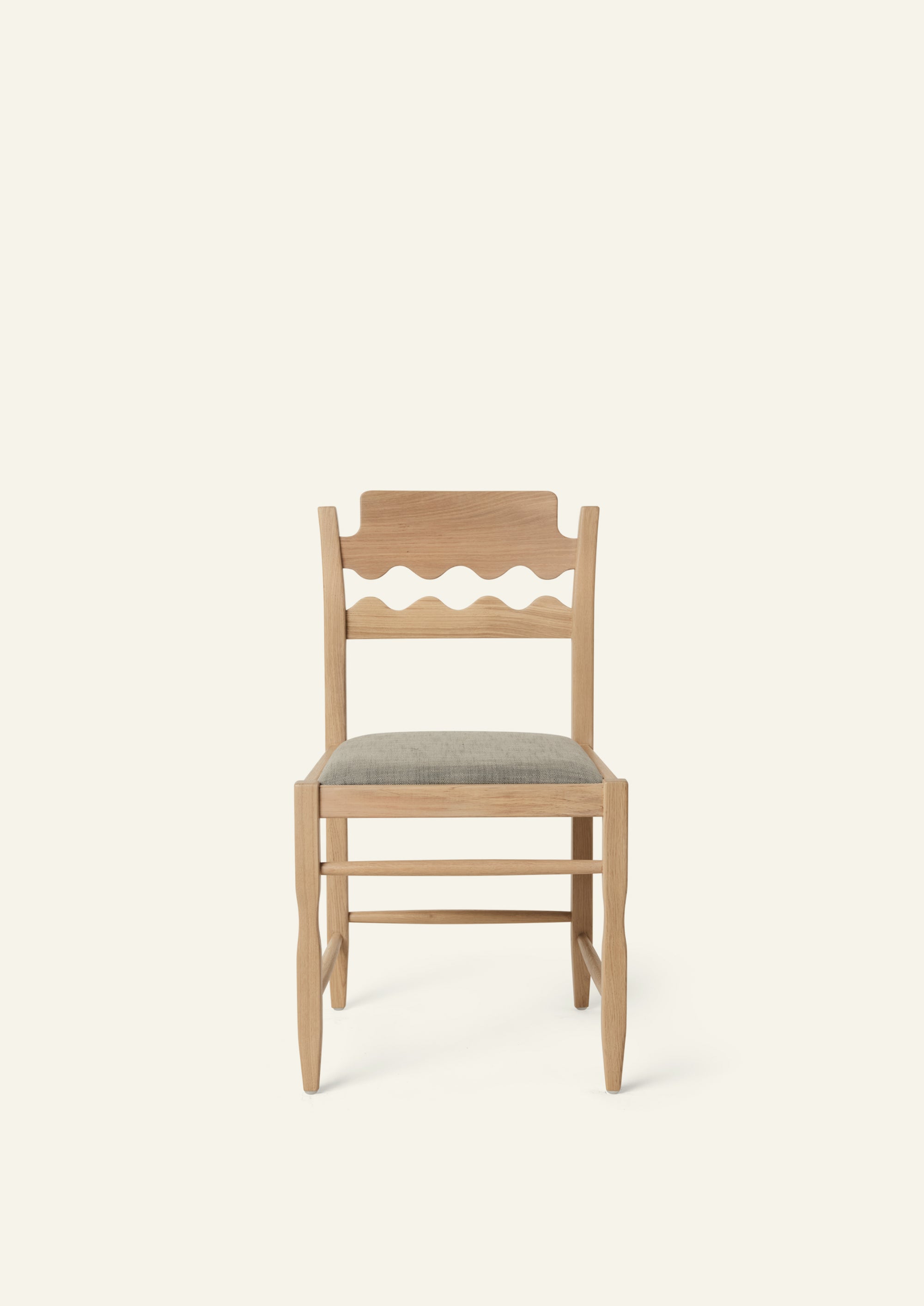 Front view of the Freda Razor Dining Chair in natural oak with an upholstered performance slate linen seat. The hand-carved scalloped backrest adds a playful yet timeless detail.