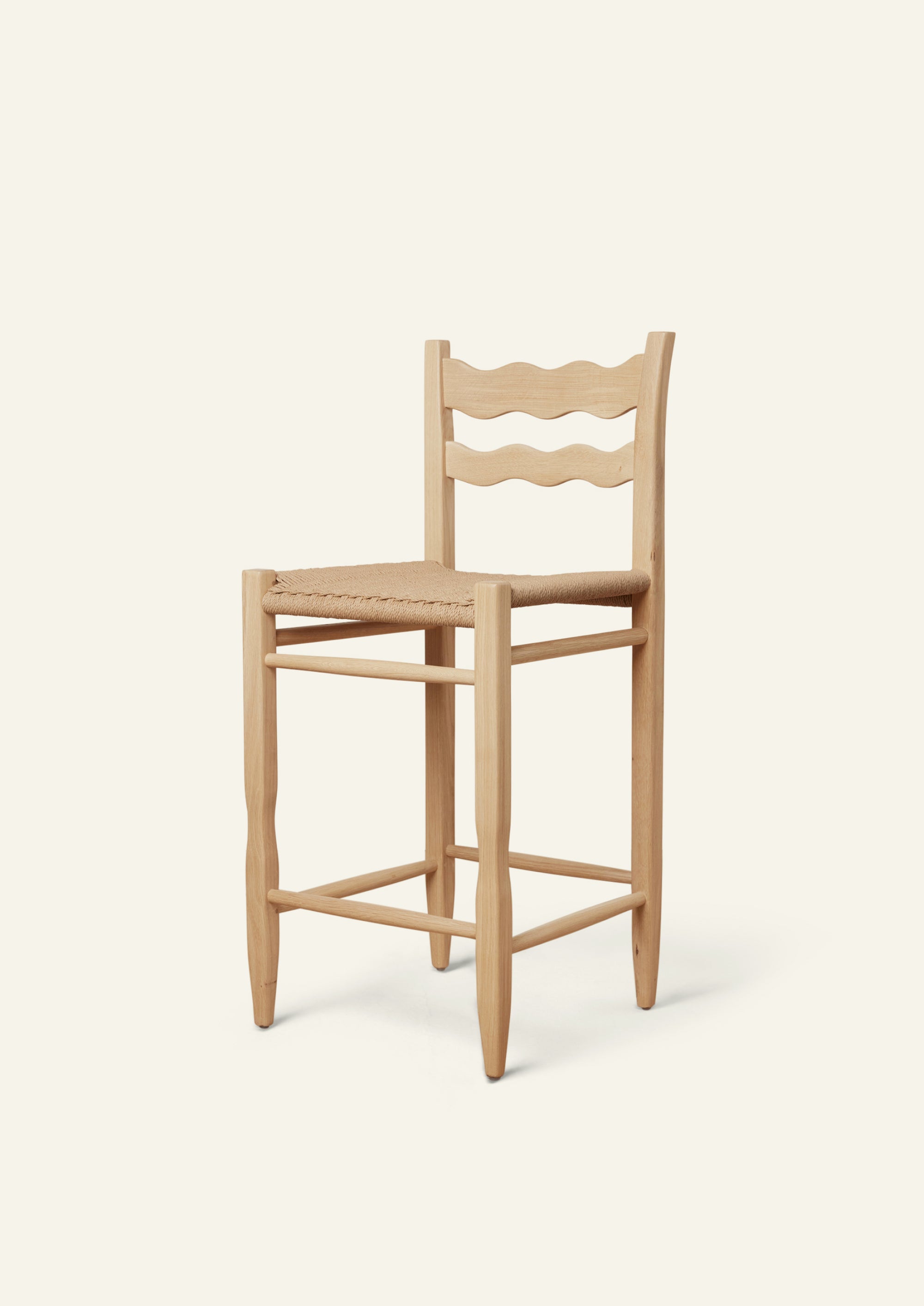 Freda Wave Counter Stool in natural oak with a paper cord seat, shown from an angled front view on a neutral background. The chair features Freda’s signature double-wave backrest with softly sculpted, hand-carved detailing.
