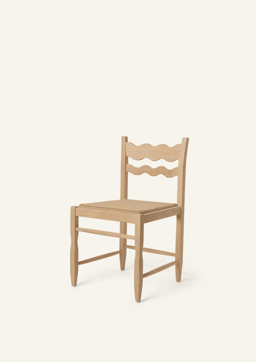 Freda Wave Dining Chair in natural oak with a woven paper cord seat, shown from an angled front view on a neutral background. The hand-carved scalloped backrest adds a playful yet timeless detail.