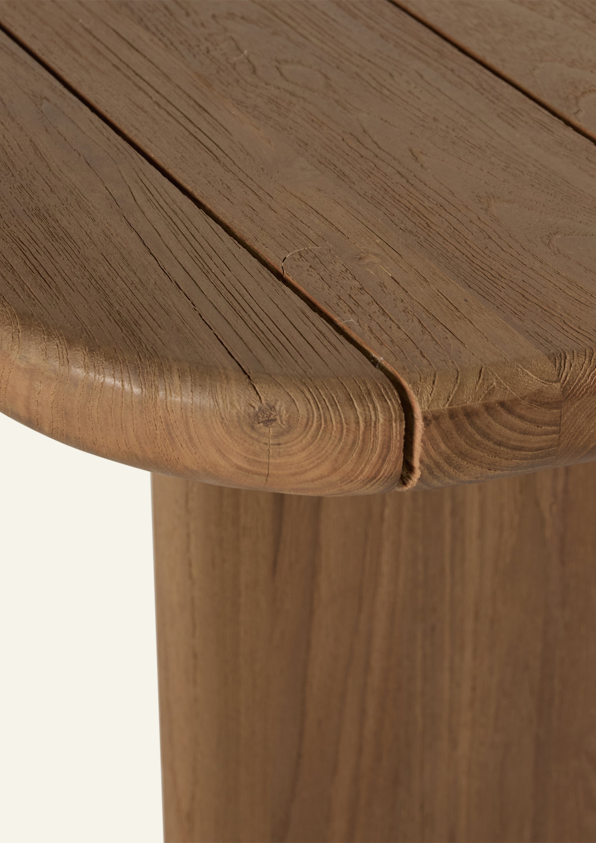 Close-up of the reclaimed teak tabletop highlighting the rounded corners, slatted construction, and weathered grain patterns. Natural variations in tone and texture reflect the character of aged teak.