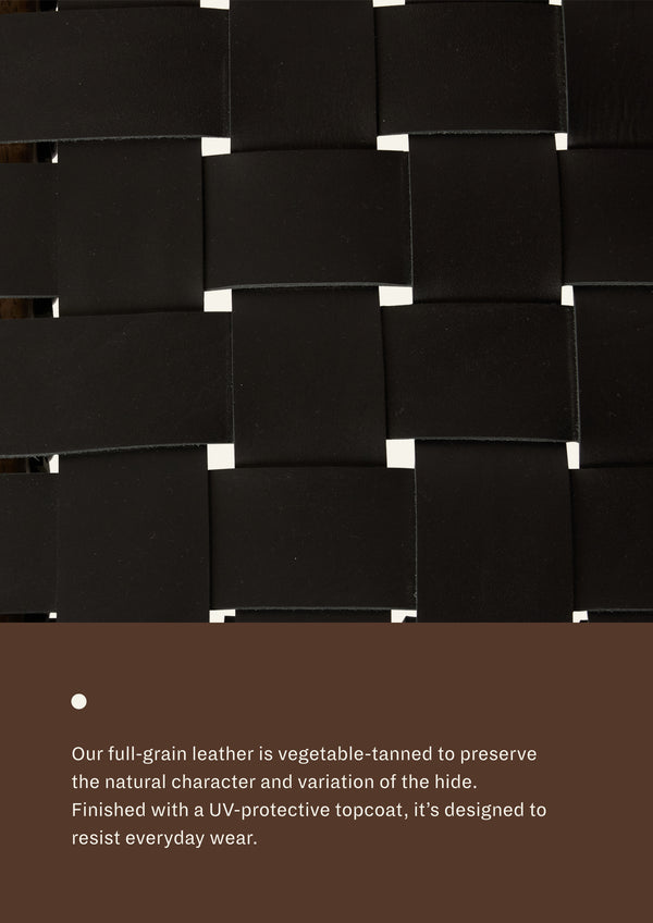 Close-up detail of woven black full-grain leather showing the basket-weave construction, smooth finish, and rich depth of color that develops character over time.