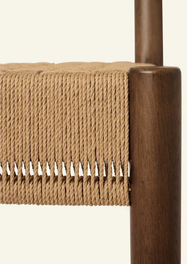 Close-up of the woven seat and solid brown oak joinery, emphasizing the craftsmanship and texture of the Isa Counter Stool.