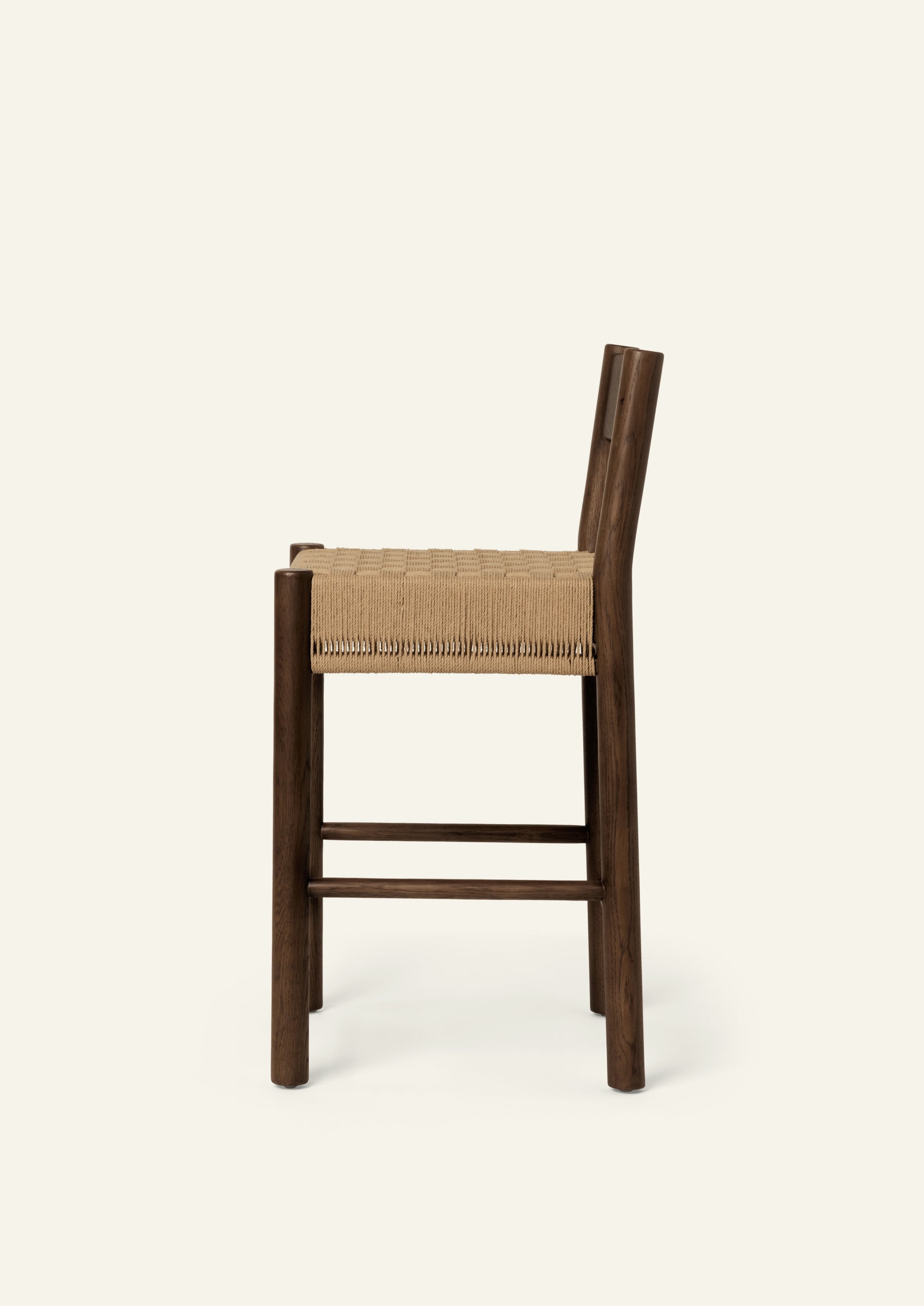 Profile view of the Isa Counter Stool showcasing its classic design, woven seat, and solid brown oak frame.