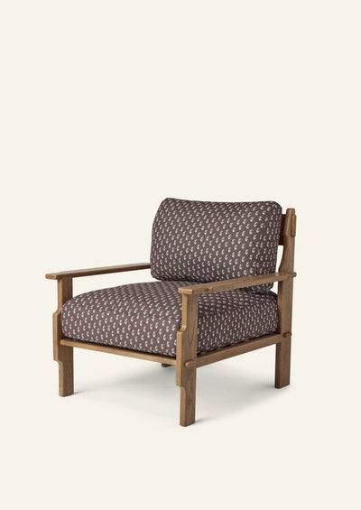 Lounge chair upholstered in brown floral fabric with a solid honey oak frame. Plush seat and back cushions pair with handcrafted wood detailing for a relaxed, inviting silhouette.
