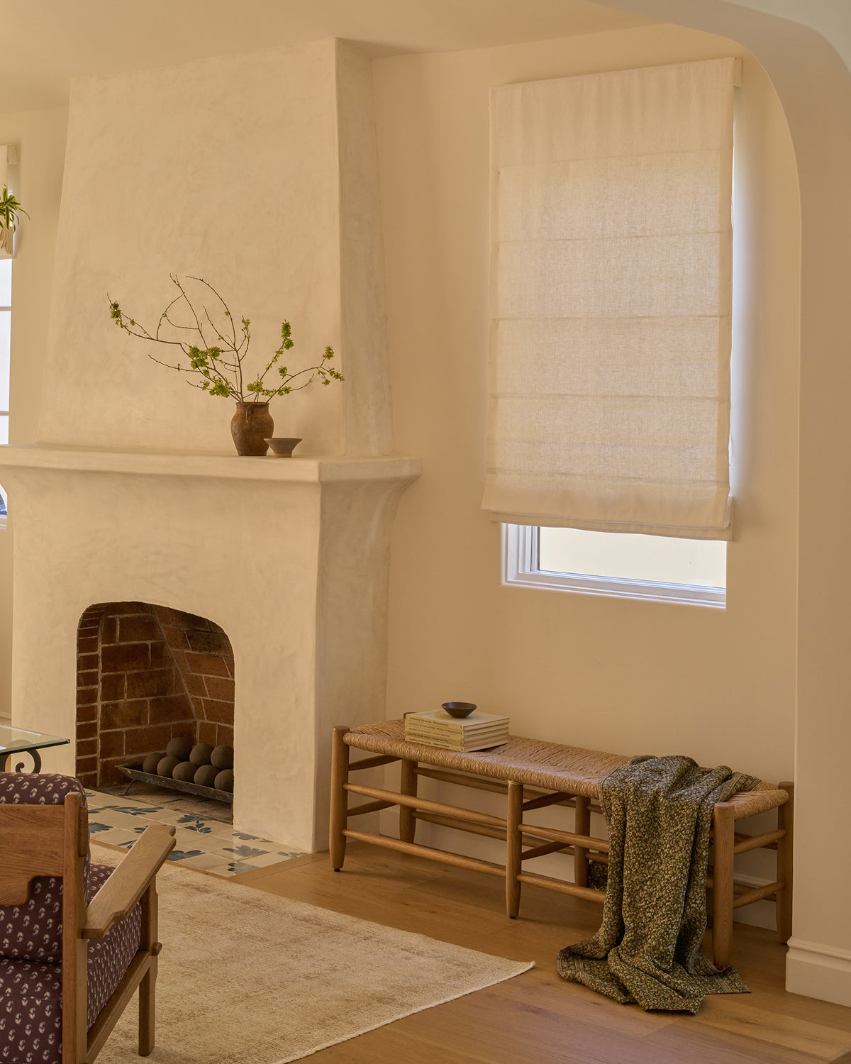 Living room with a fireplace, Mina honey oak bench, and window with blinds.