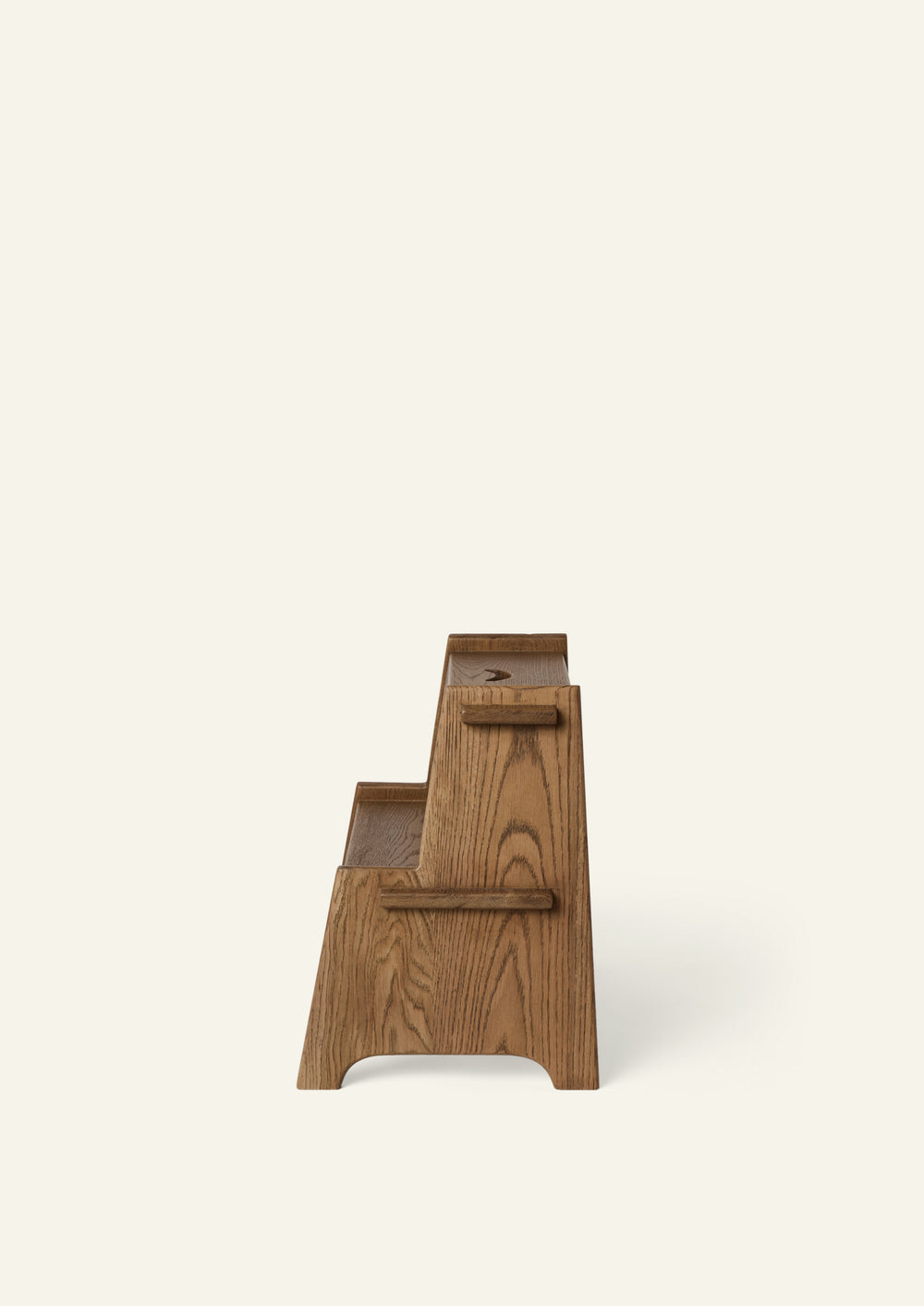 Side profile of the Margot Step Stool highlighting its stepped silhouette, solid oak construction, and decorative scalloped details. The angled supports provide stability while maintaining an elegant, handcrafted appearance.