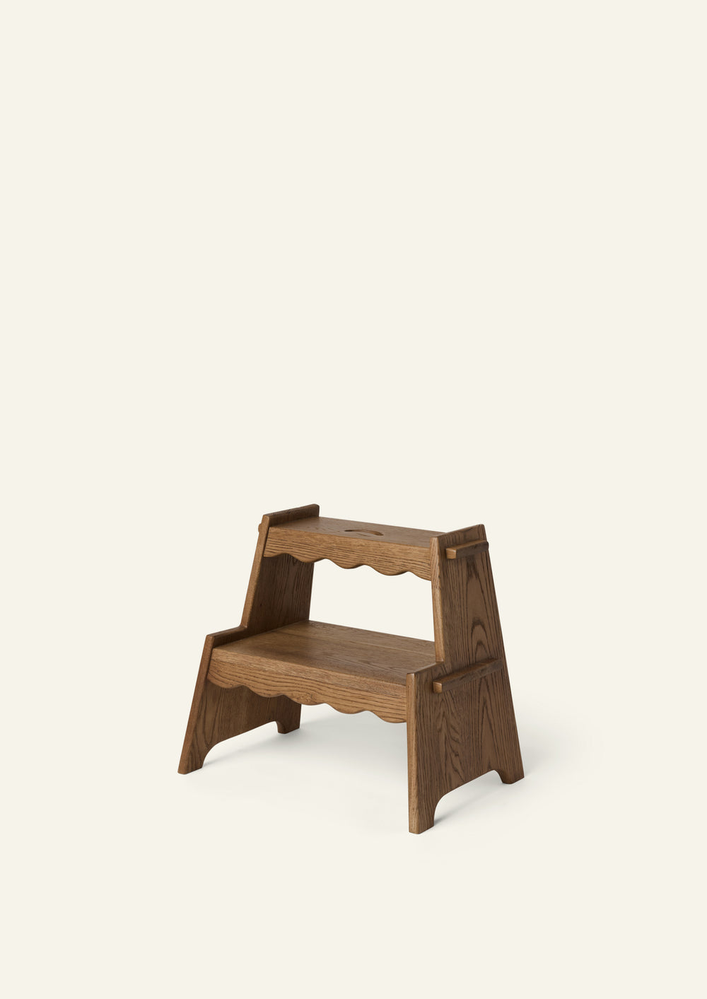 Three-quarter view of the Margot Step Stool in Honey Oak. Crafted from solid oak, the two-step design features scalloped detailing, integrated handholds, and a warm, timeless finish.
