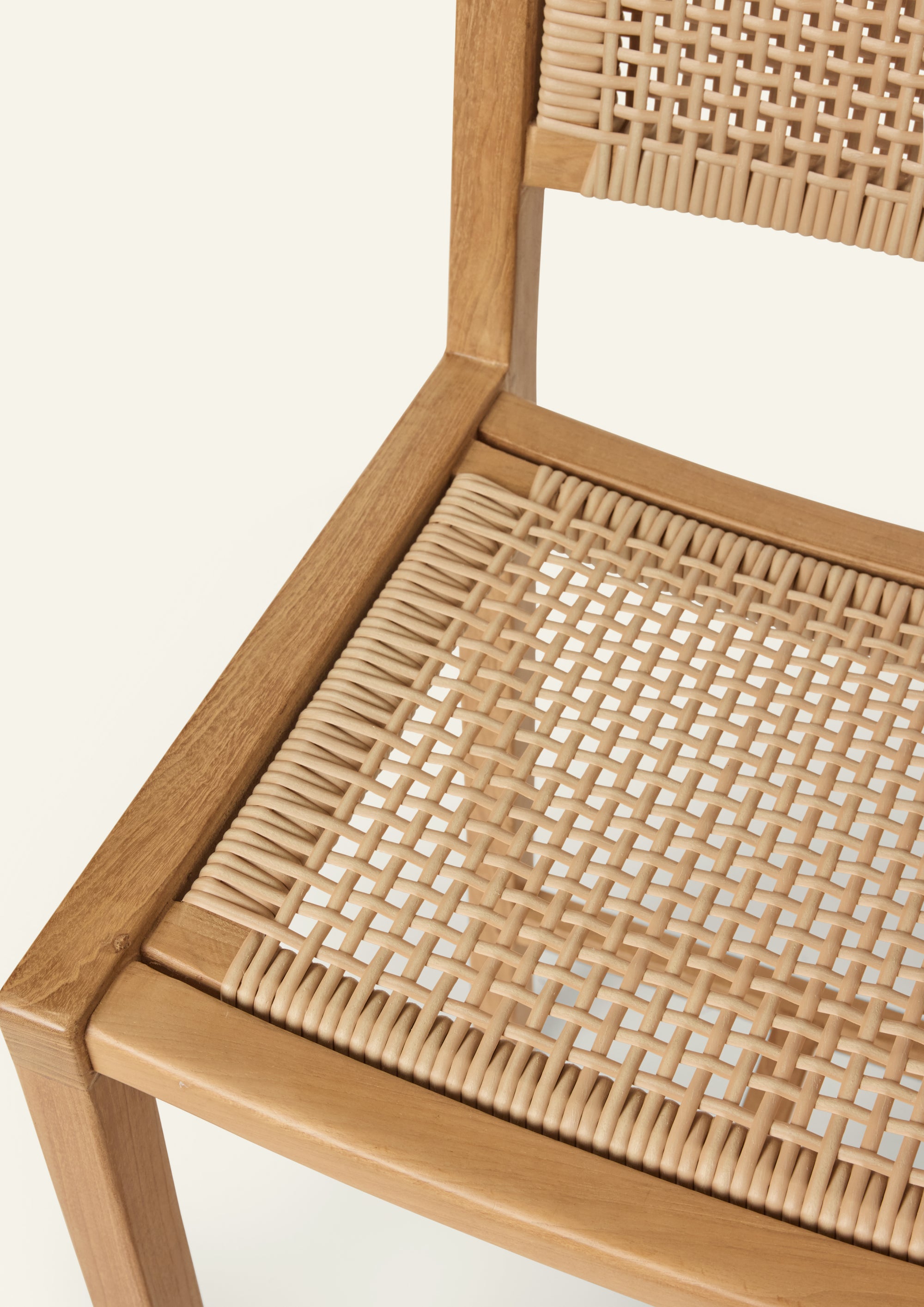 Close-up of the synthetic rattan seat and solid teak frame, emphasizing the material contrast and handcrafted construction of the Nusa Counter Stool.
