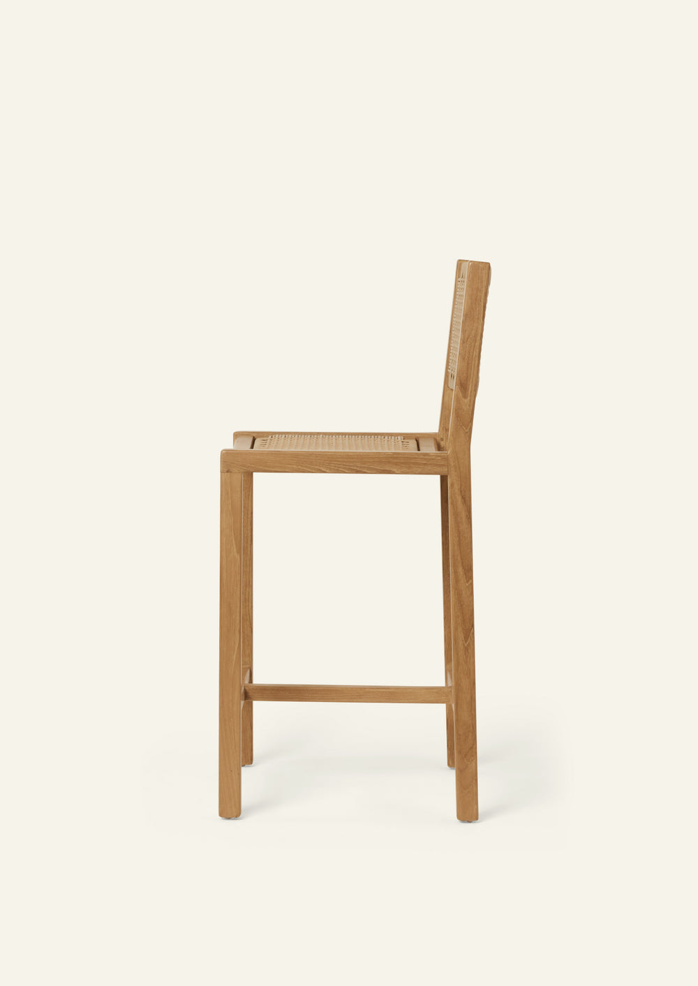 Side profile of the Nusa Counter Stool featuring a streamlined teak frame, woven synthetic rattan seat, and supportive backrest.