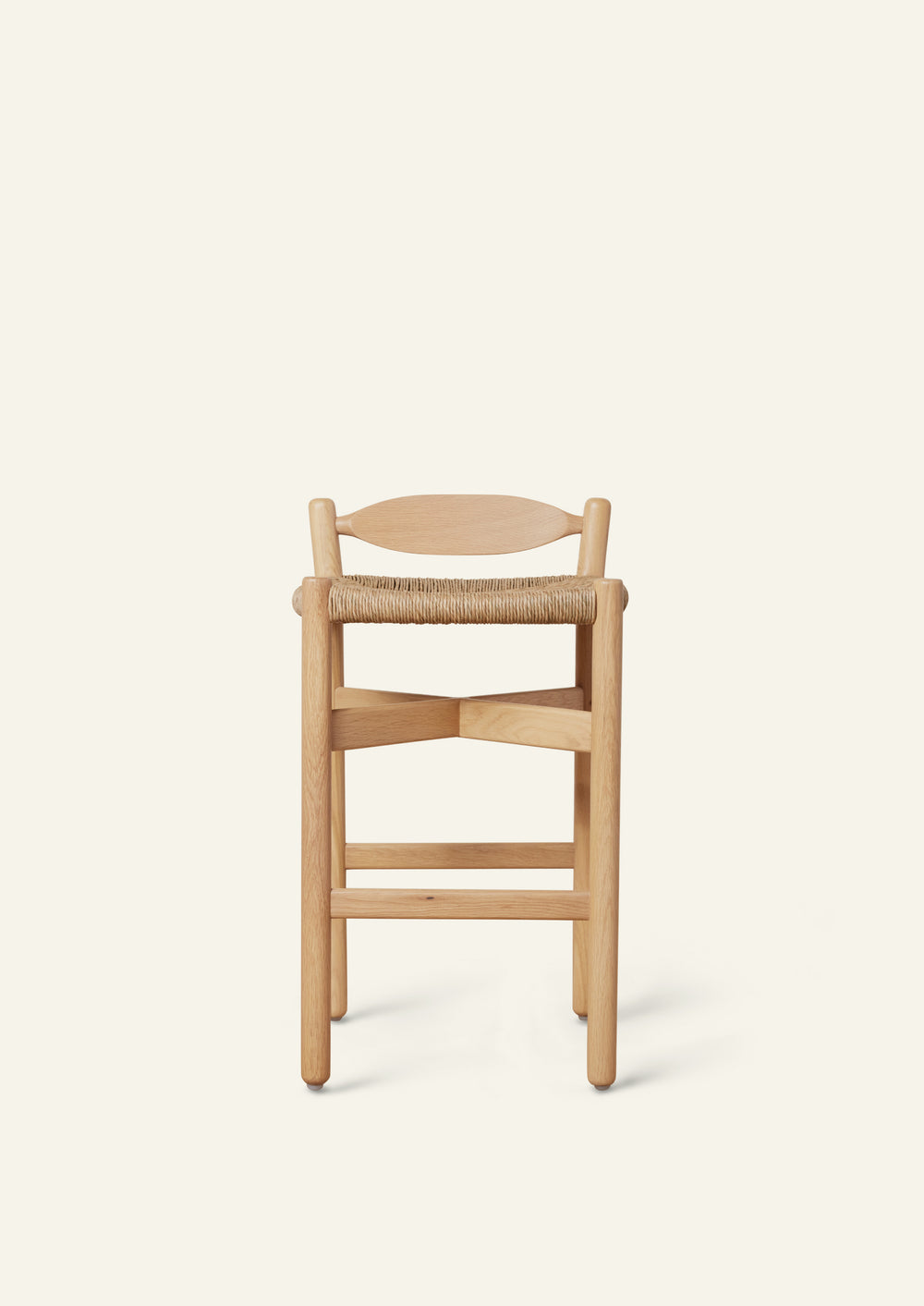 Front view of the Olma Counter Stool featuring a handwoven rush seat, supportive curved back, and streamlined silhouette.