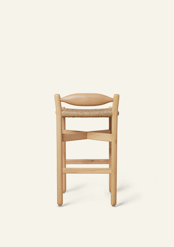 Straight-on rear view showcasing the stool's balanced proportions, woven rush detailing, and solid white oak frame.