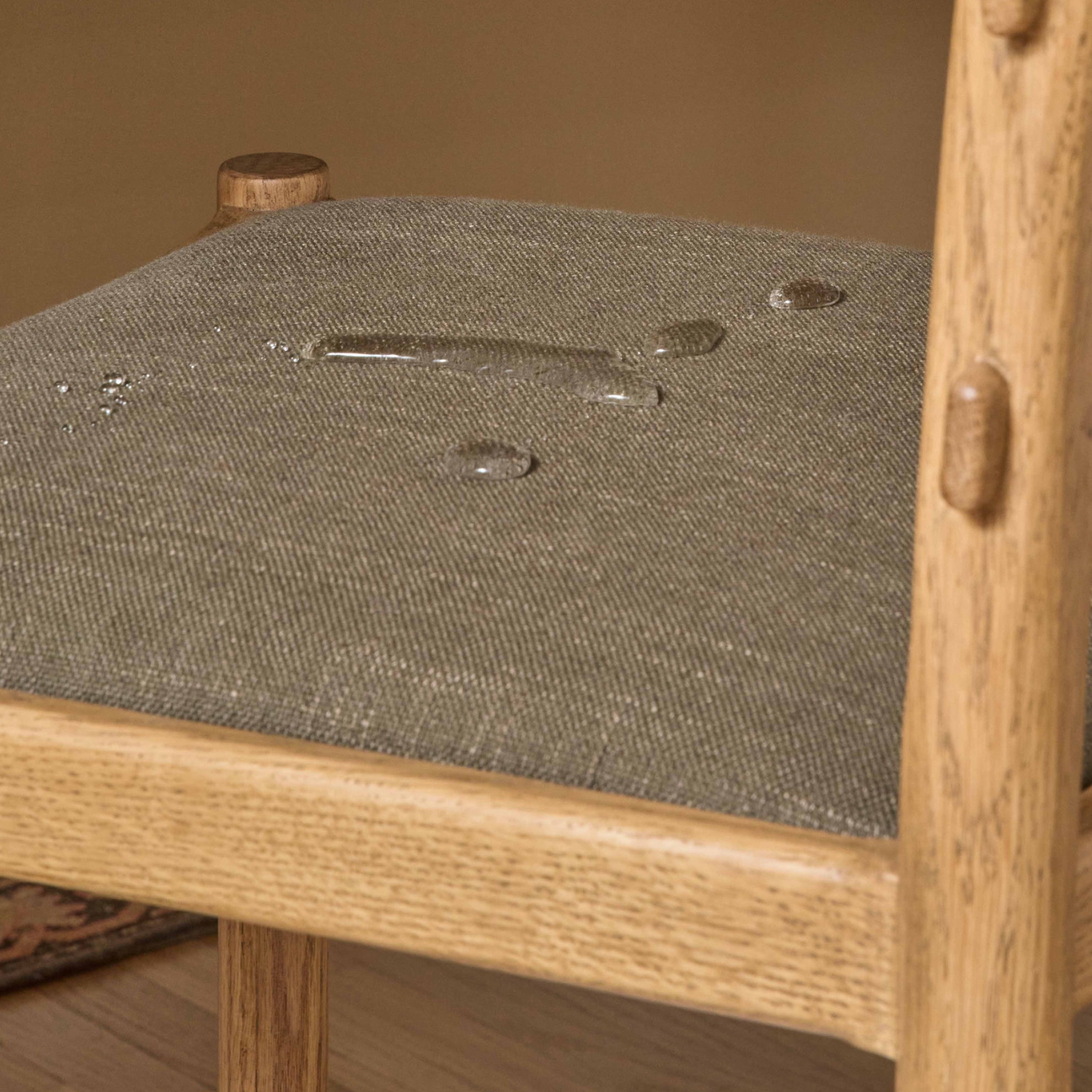 Drops of water bubbling on performance linen counter stool seat. 