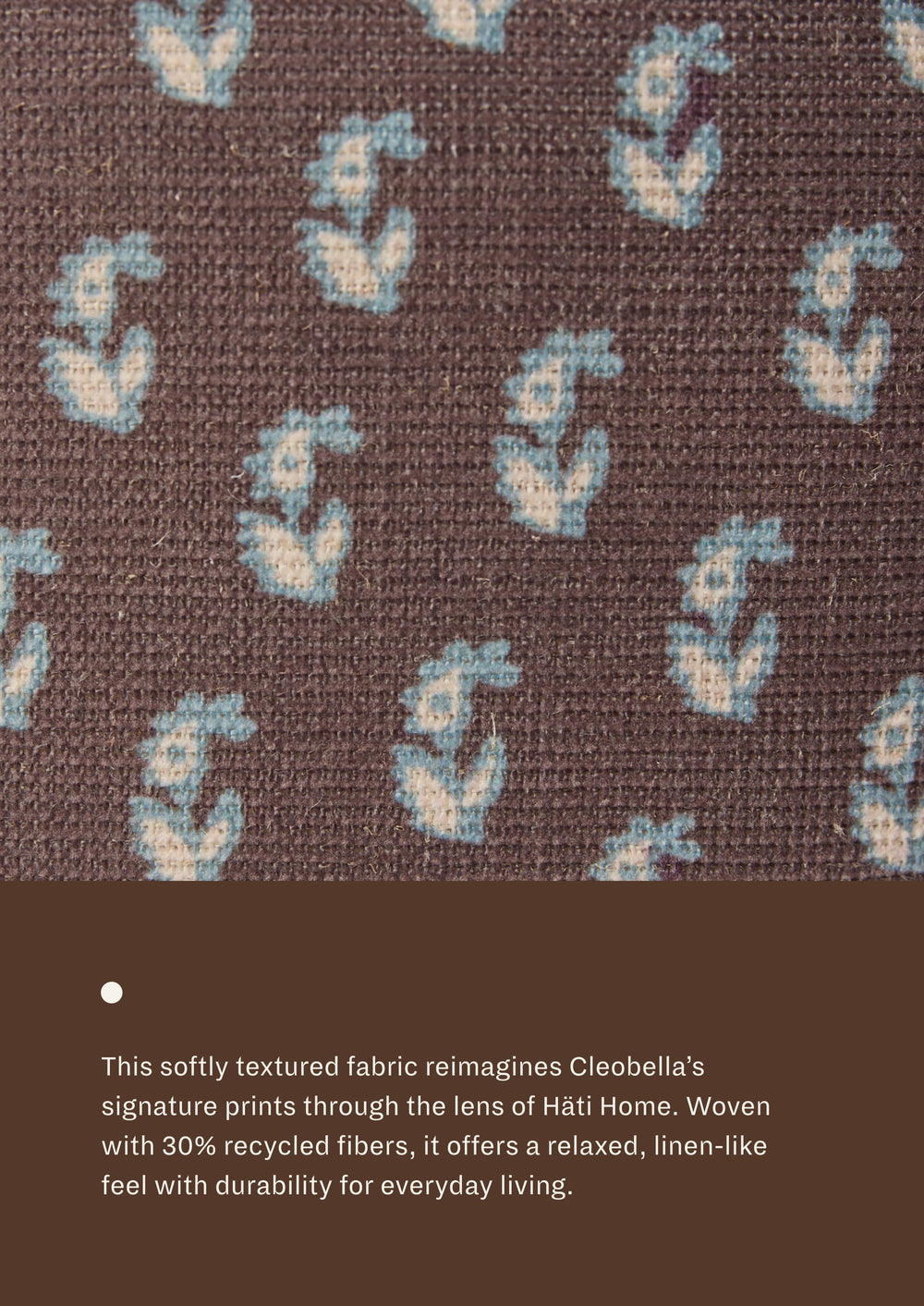 Close-up of floral brown fabric featuring a delicate floral motif in soft blue and ivory on a chocolate-brown background. Woven with recycled fibers, the textile offers a relaxed, linen-like texture designed for everyday durability.