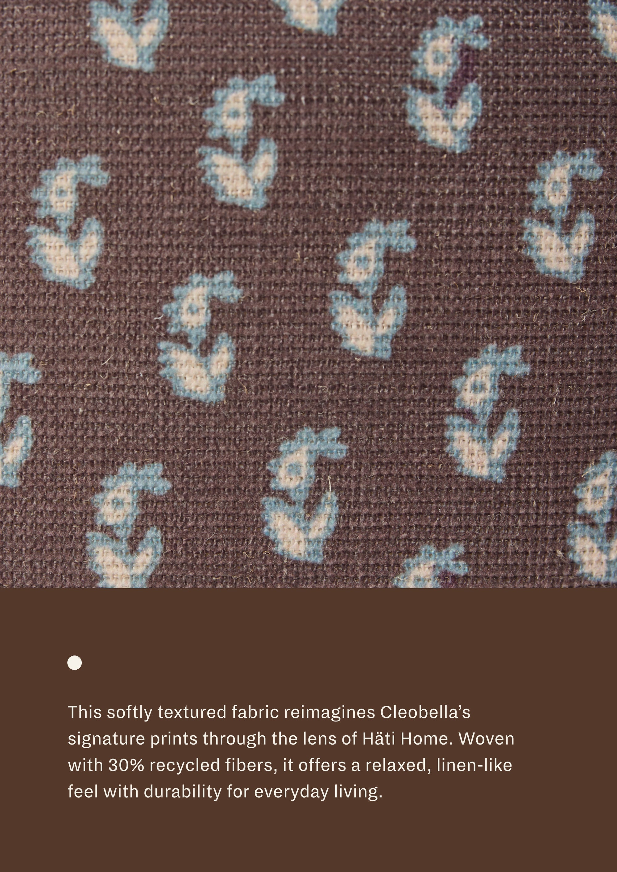 Close-up of floral brown fabric featuring a delicate floral motif in soft blue and ivory on a chocolate-brown background. Woven with recycled fibers, the textile offers a relaxed, linen-like texture designed for everyday durability.
