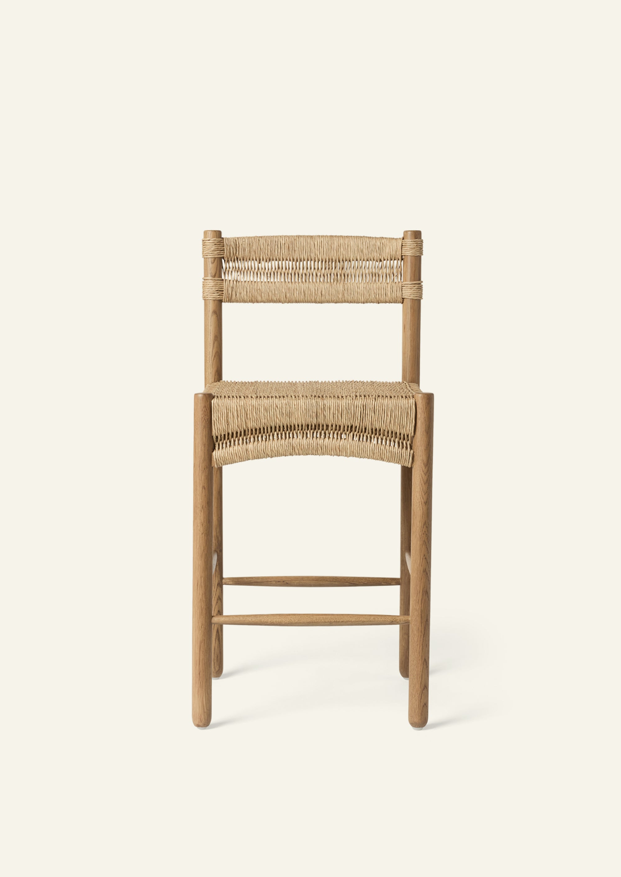 Front view of the counter stool featuring a woven rush seat and backrest supported by a solid honey oak frame. The gently curved seat detail provides visual softness and everyday comfort.