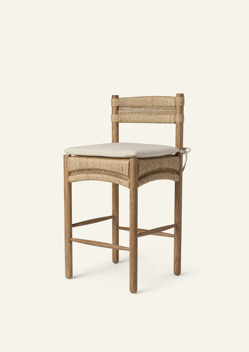 Three-quarter view of a counter stool crafted from solid honey oak and handwoven natural rush with a custom made seat cushion in an ivory performance tweed fabric. 