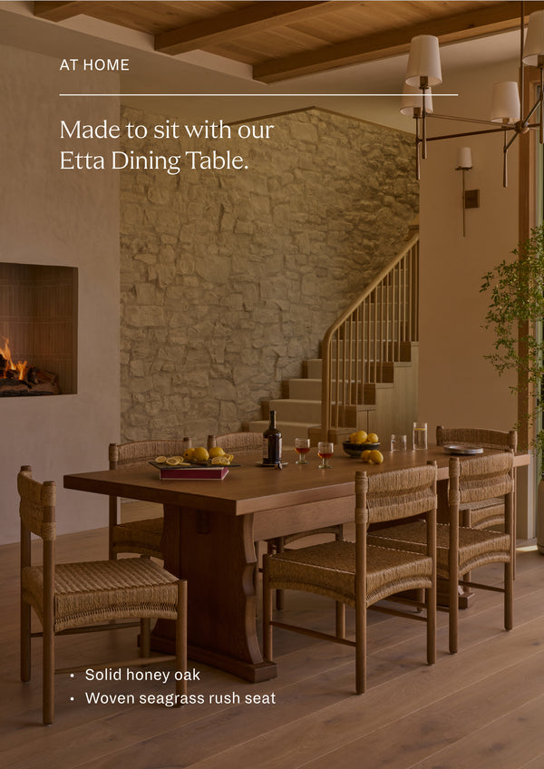 Made to sit with our Etta Dining Table. A collection of woven rush dining chairs gathered around a solid oak dining table in a warm, inviting interior. The natural textures and organic materials create a relaxed, timeless dining setting.