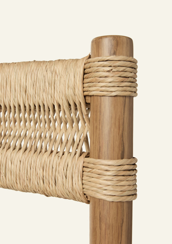Close-up of the handwoven rush backrest wrapped around a solid oak frame. The intricate weaving pattern highlights the craftsmanship and natural texture of the material.