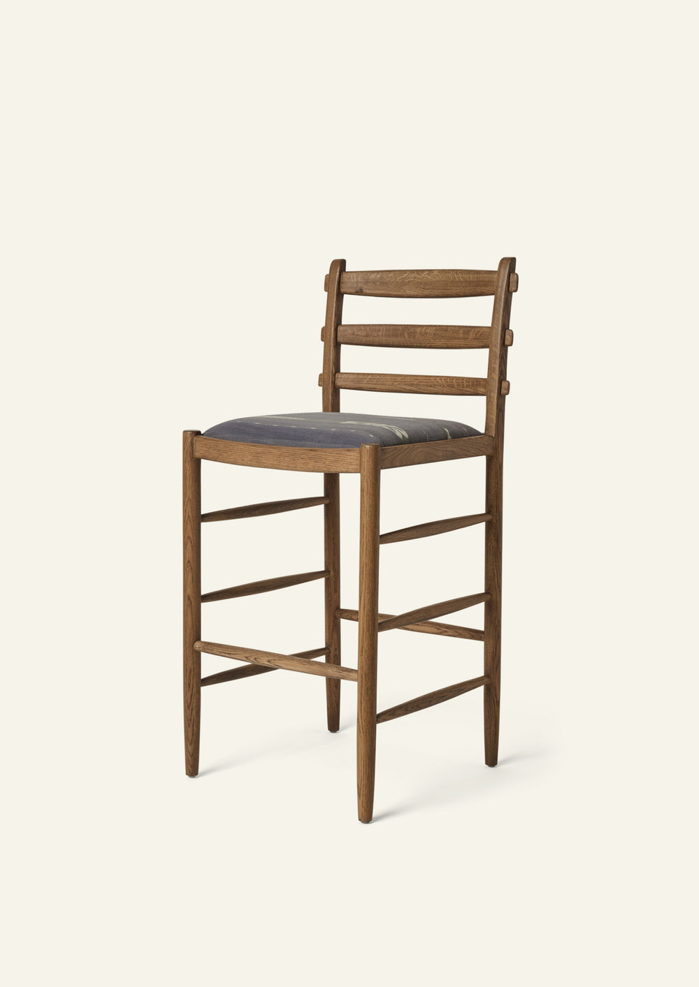 Tiga Counter Stool with a solid honey oak frame and a custom upholstered seat, shown from an angled front view on a neutral background.