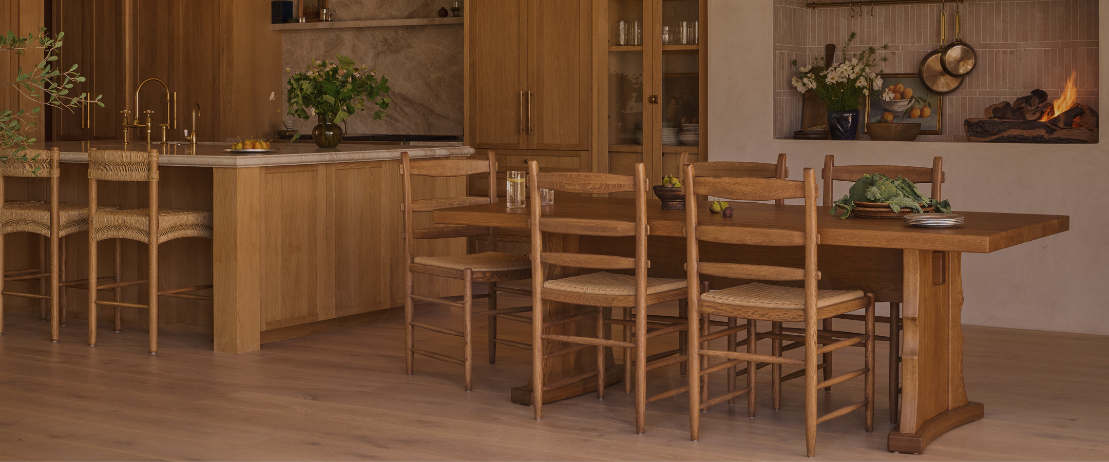 Warm, neutral kitchen with a European inspired fireplace and large Etta dining table with Tiga honey oak dining chairs. 