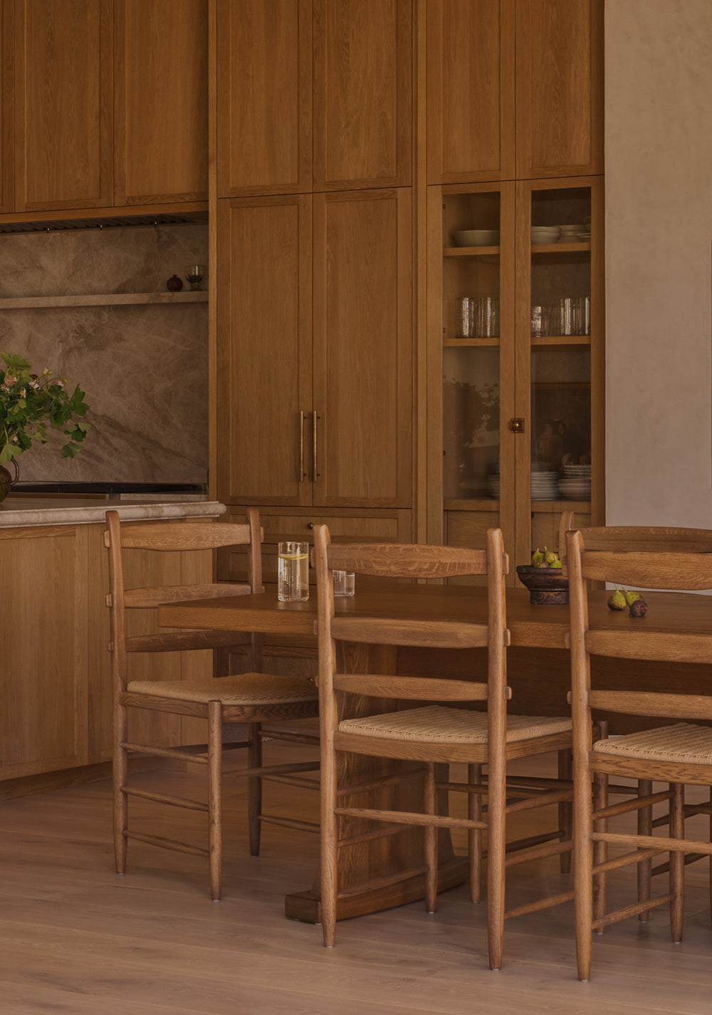 Warm, neutral kitchen with a European inspired fireplace and large Etta dining table with Tiga honey oak dining chairs. 