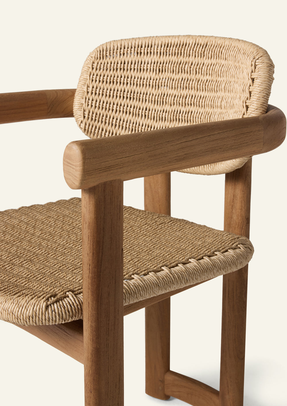 Detailed view of the chair’s woven backrest and seat, featuring tightly woven synthetic paper cord paired with a solid teak frame. The organic textures contrast beautifully with the clean architectural structure.