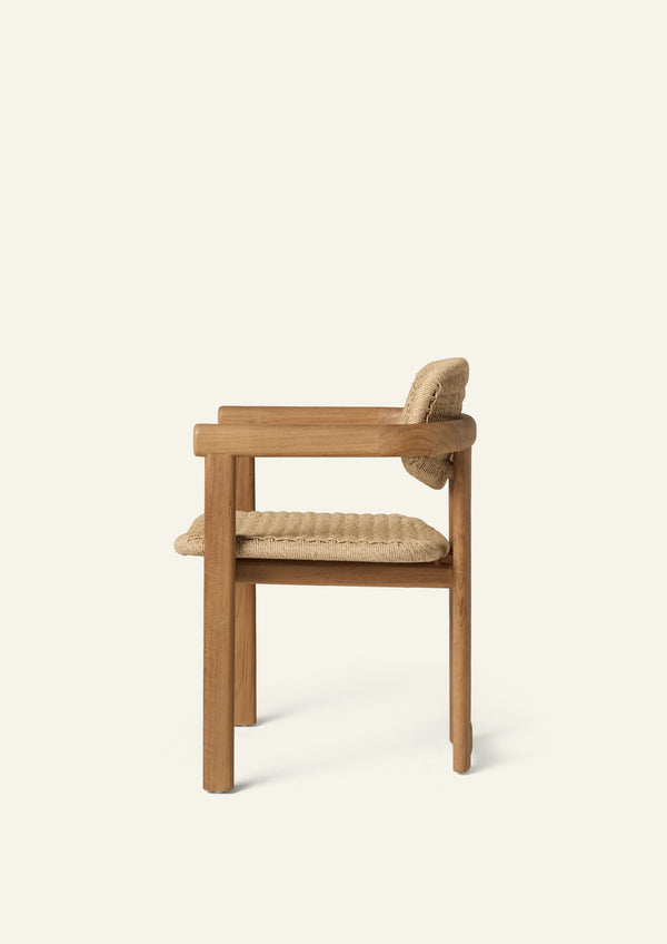 Side profile of the dining armchair showcasing its gently reclined woven backrest, supportive seat, and solid teak frame. Designed for everyday comfort, the chair combines durable outdoor materials with a refined silhouette.