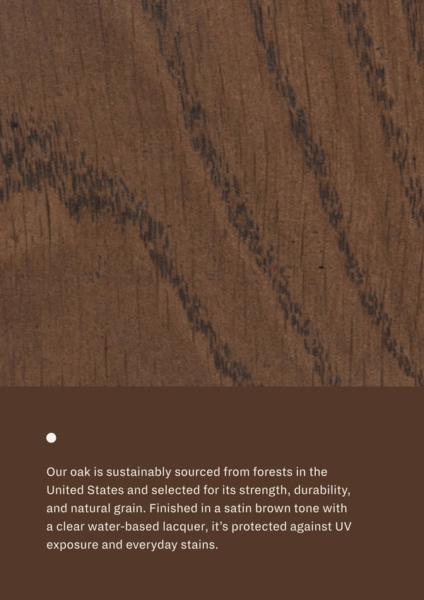 Close-up image of brown oak wood grain with accompanying material information describing sustainably sourced oak, its natural durability and strength, and a satin brown finish protected by a clear water-based lacquer.