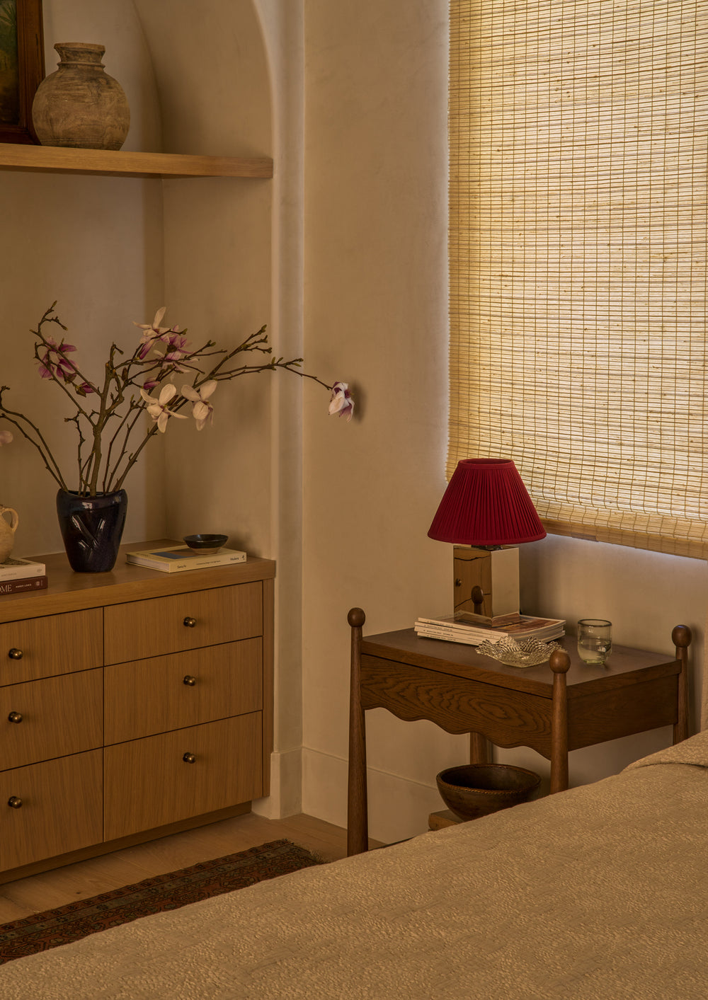 Warm bedroom with Wave brown oak nightstand, a built-in dresser and shelf with styled areas. 