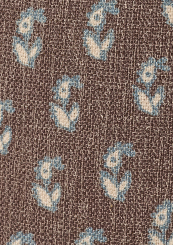 Close-up of the Cocoa Floral fabric by Cleobella. A cool brown base with individual paisleys in ivory with a blue outline.