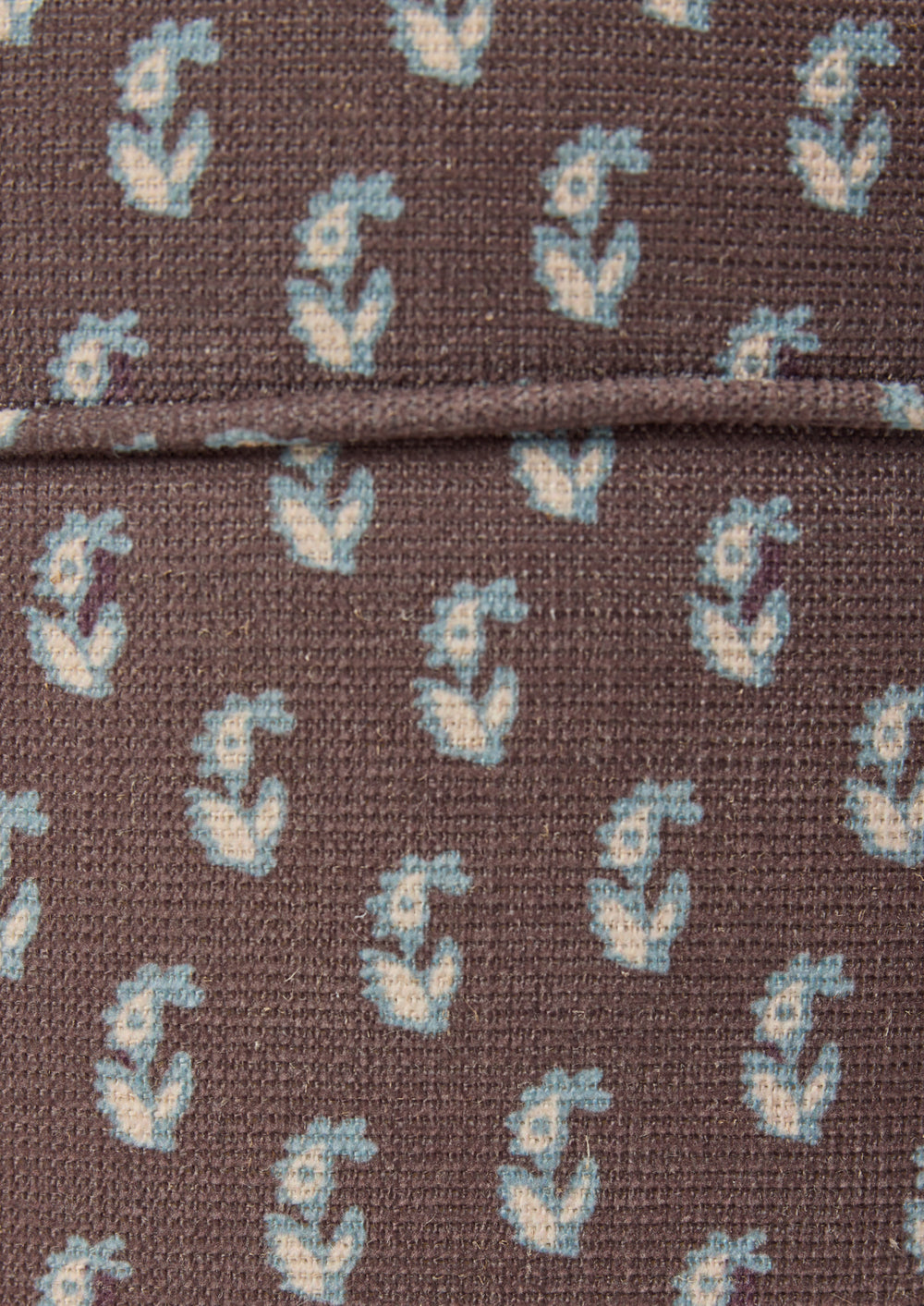 Close-up of the Cocoa Floral fabric by Cleobella. A cool brown base with individual paisleys in ivory with a blue outline.