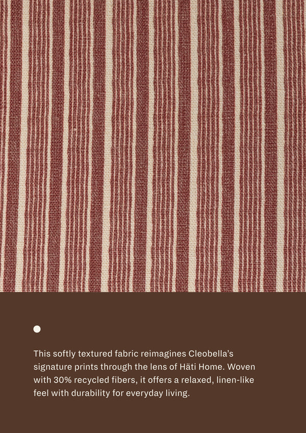 Close-up of the Oxblod Stripe fabric featuring alternating burgundy-red and ivory stripes. Woven with recycled fibers, the textile offers a relaxed, linen-like texture designed for everyday durability and comfort.