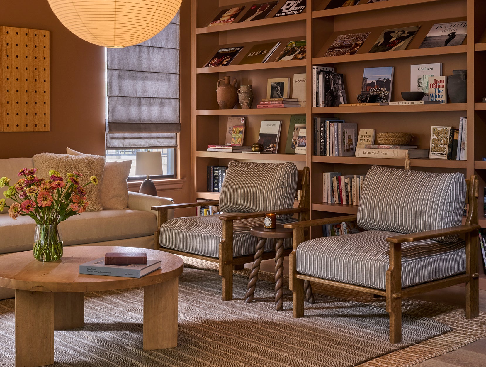 Living room with Leela lounge chairs, Twist side table, bookshelves, and decorative items.