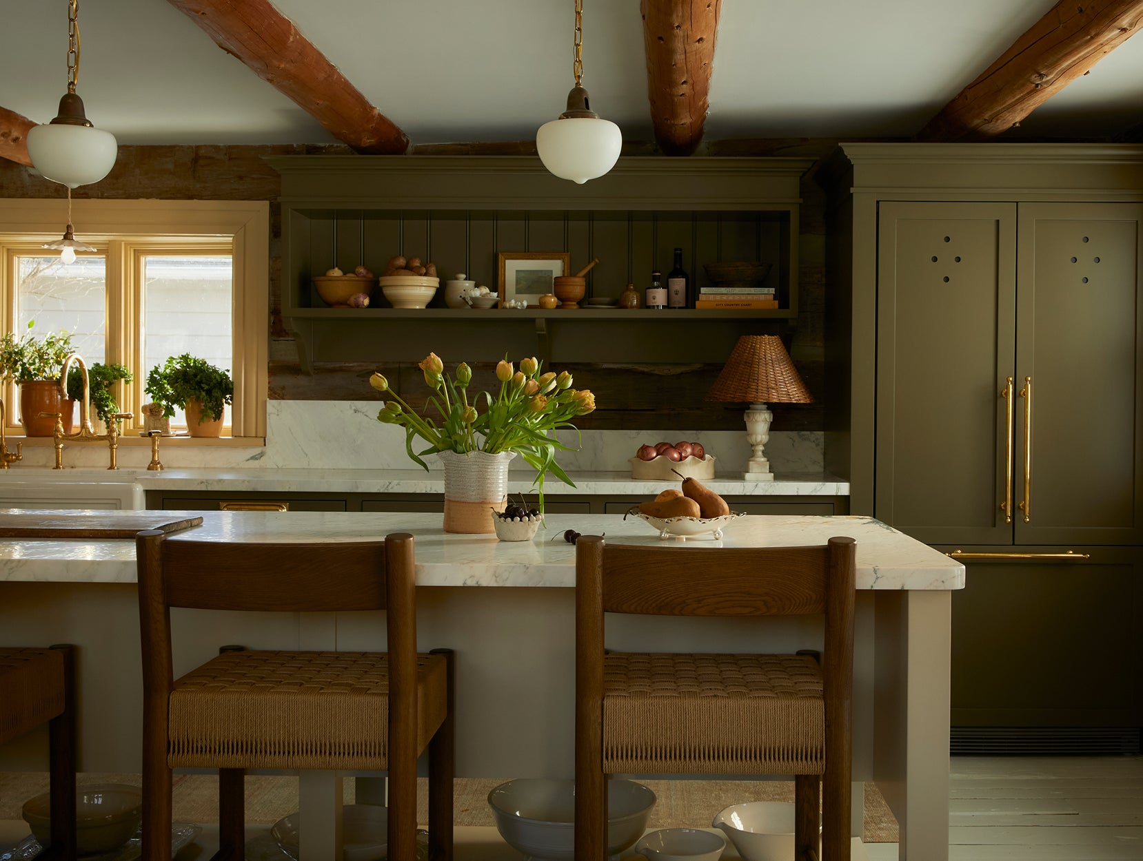Modern kitchen with wooden cabinets, marble countertops, Isa counter stools, and pendant lights.